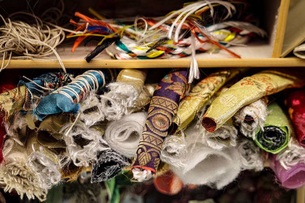 A close-up of vibrant and varied fabric rolls stacked in a textile store, showcasing textures and patterns.