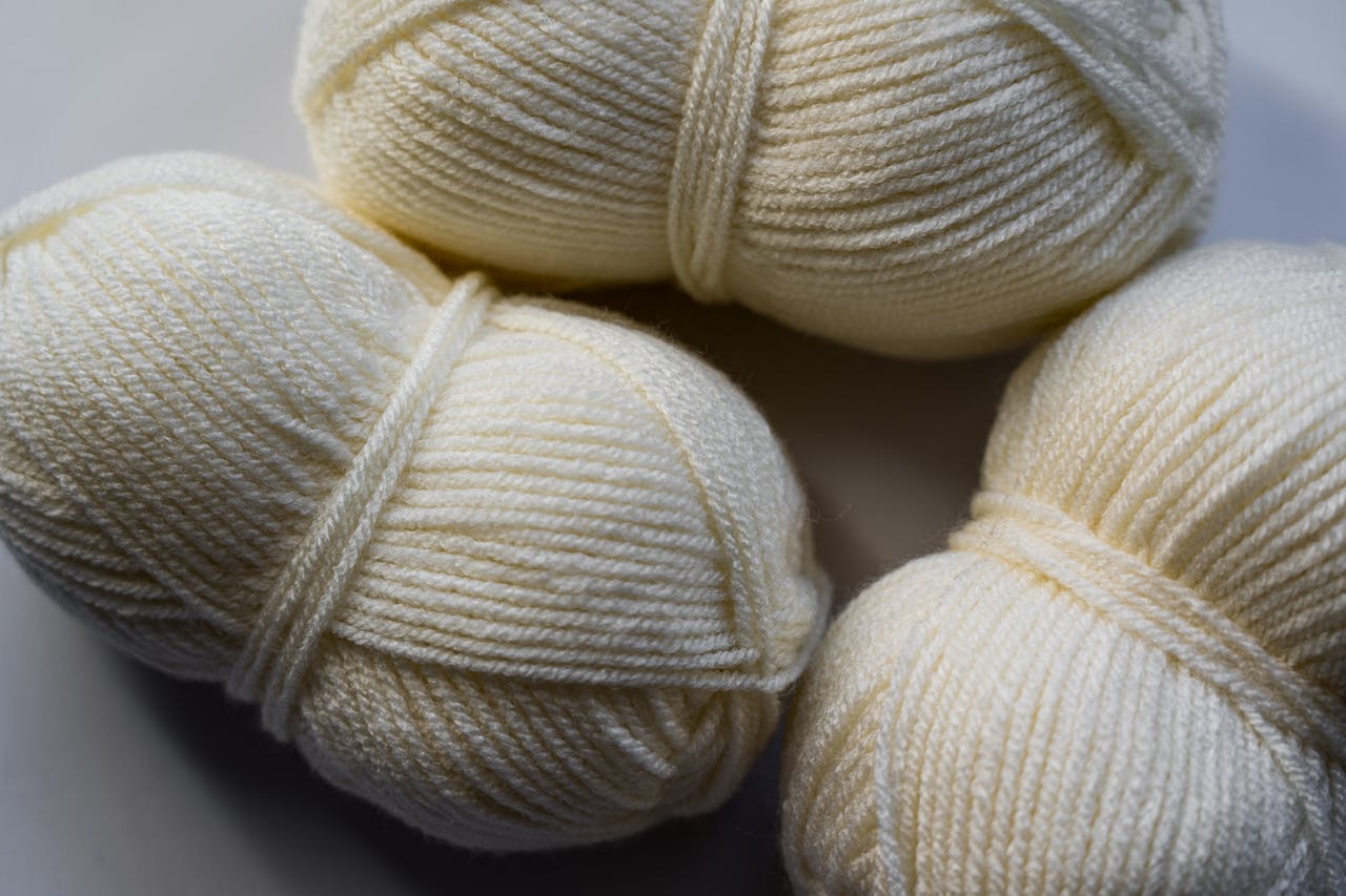 Cream wool yarn balls close-up, perfect for textile and knitting projects.